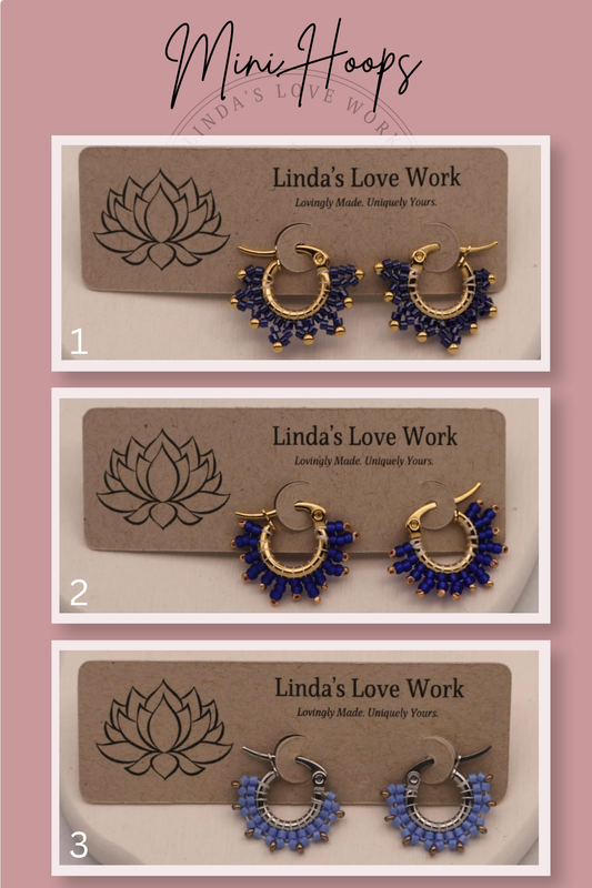 Three pairs of blue hoop earrings on 'Linda's Love Work' branded cards against a pink background.