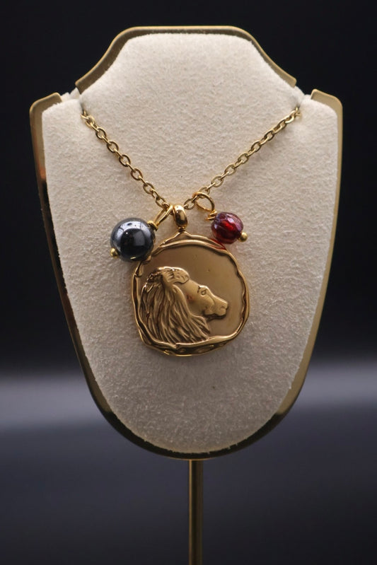 Necklace with a lion head pendant on a beige display stand against a dark background