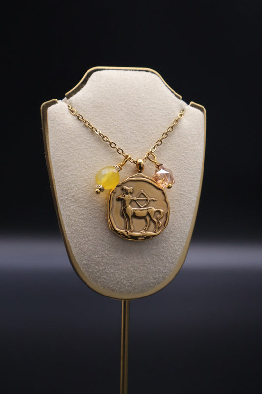 Gold necklace with a pendant on a white stand against a dark background