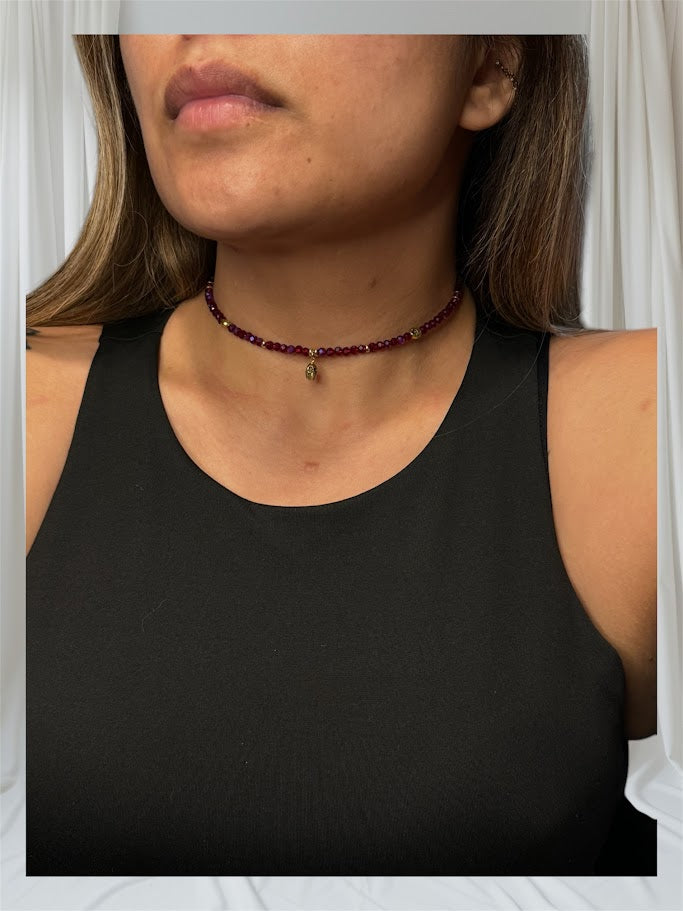 A detailed shot of the choker featuring crimson-colored beads and a skull charm at the center. The piece combines elegance with edginess, perfect for any occasion.