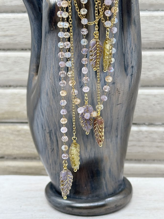 a closeup of feather beads and gold chain