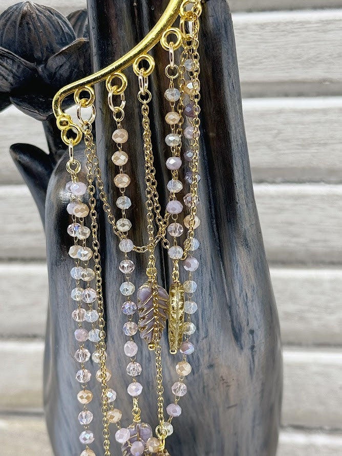 a closeup of beaded and gold chains with feather beads.