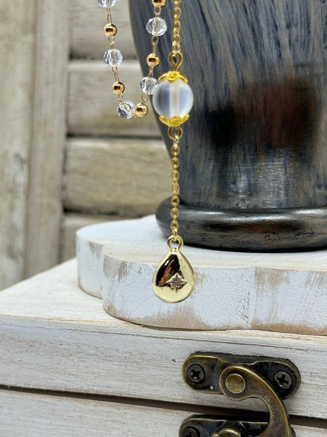 a closeup of a gold teardrop charm