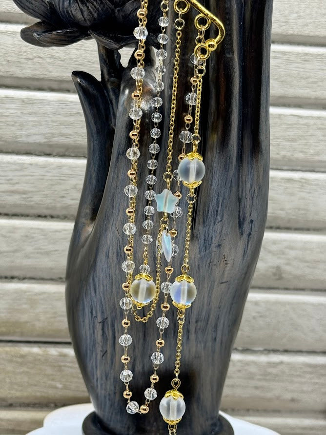 a closeup of clear crystal beaded chains with opalite and star beads