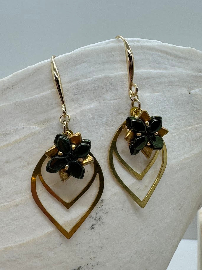 Close-up image of succulent petal earrings hanging on a minimalist jewelry display stand, showing layered petal design and fine detailing.