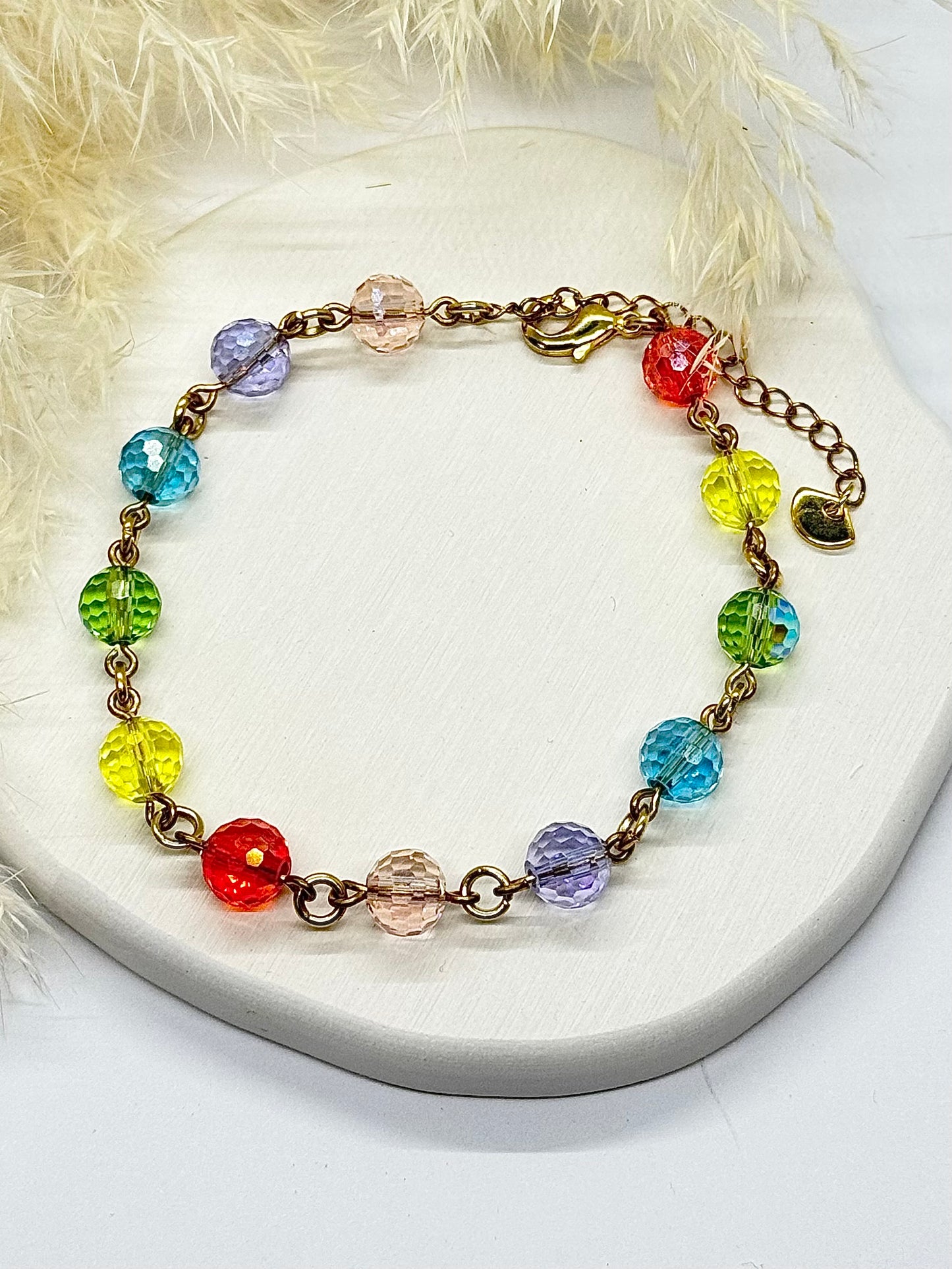 Colorful beaded bracelet on a white surface with a fluffy background