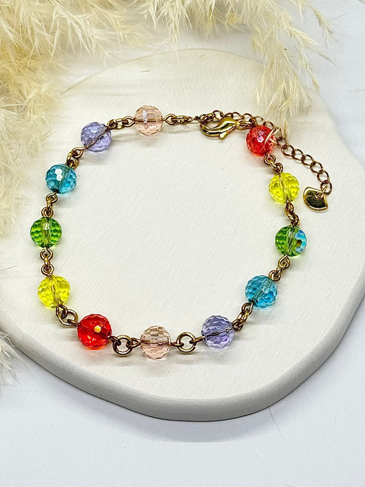 Colorful beaded bracelet on a white surface with a fluffy background