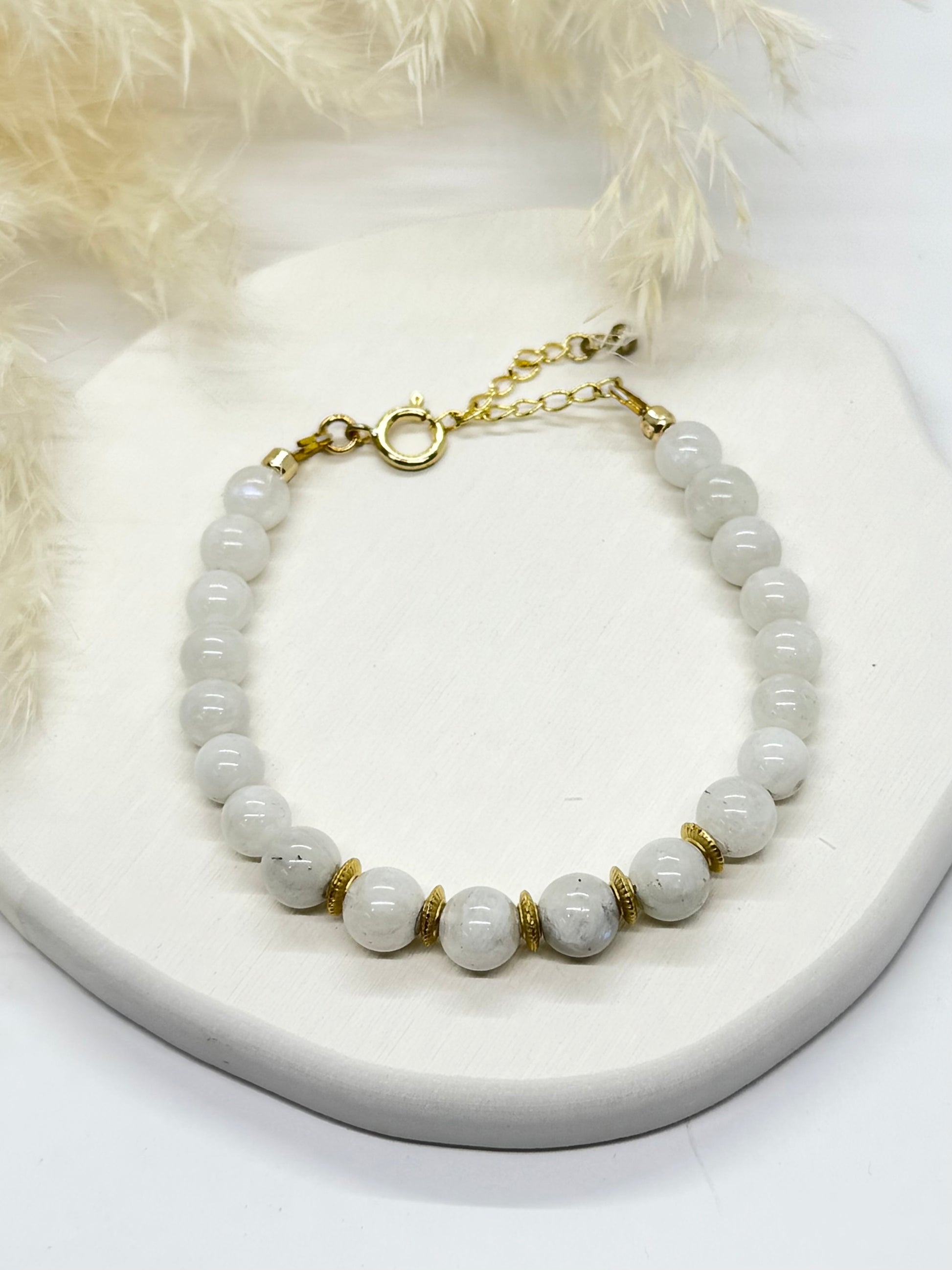 Beaded bracelet with gold accents on a white surface