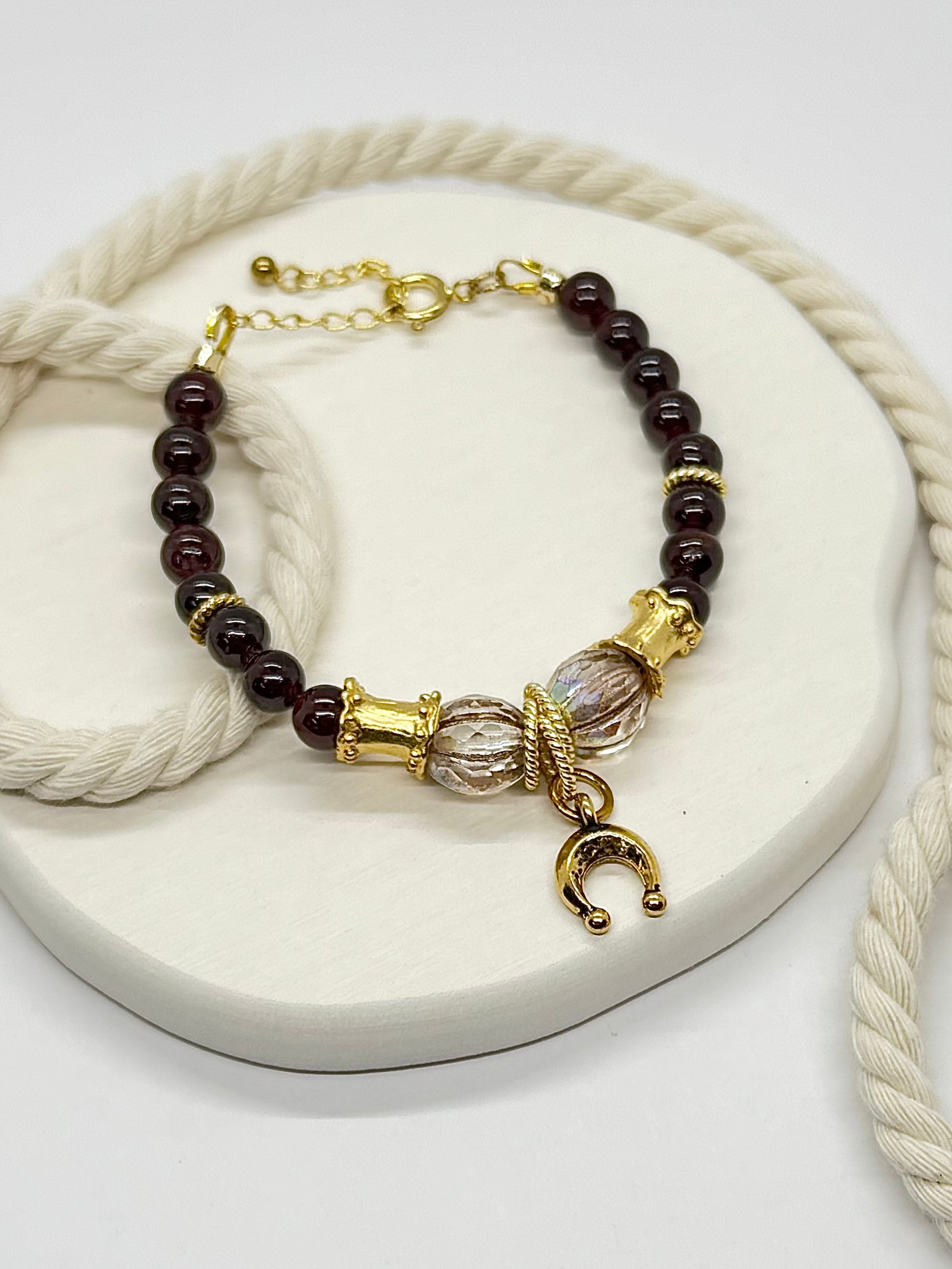 Bracelet with brown beads and gold accents on a white surface