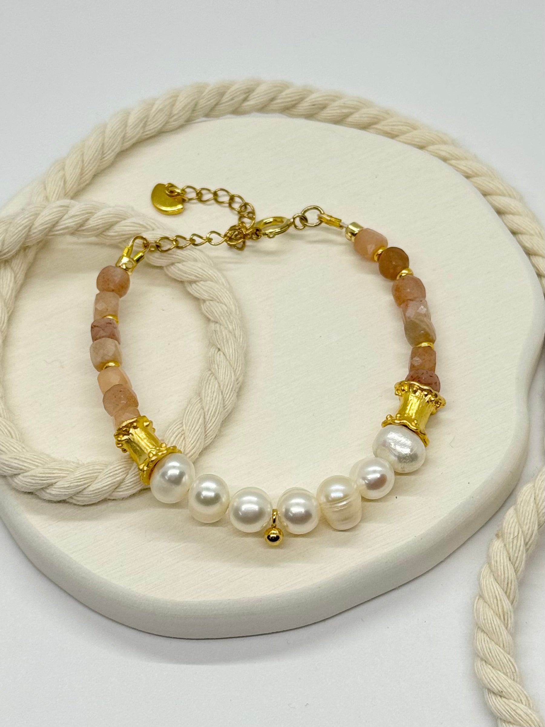 Bracelet with pearls and gold accents on a white surface