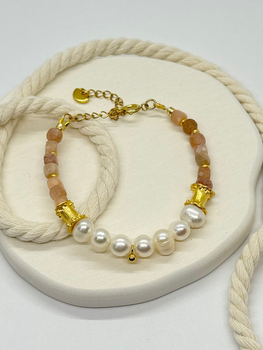 Bracelet with pearls and gold accents on a white surface