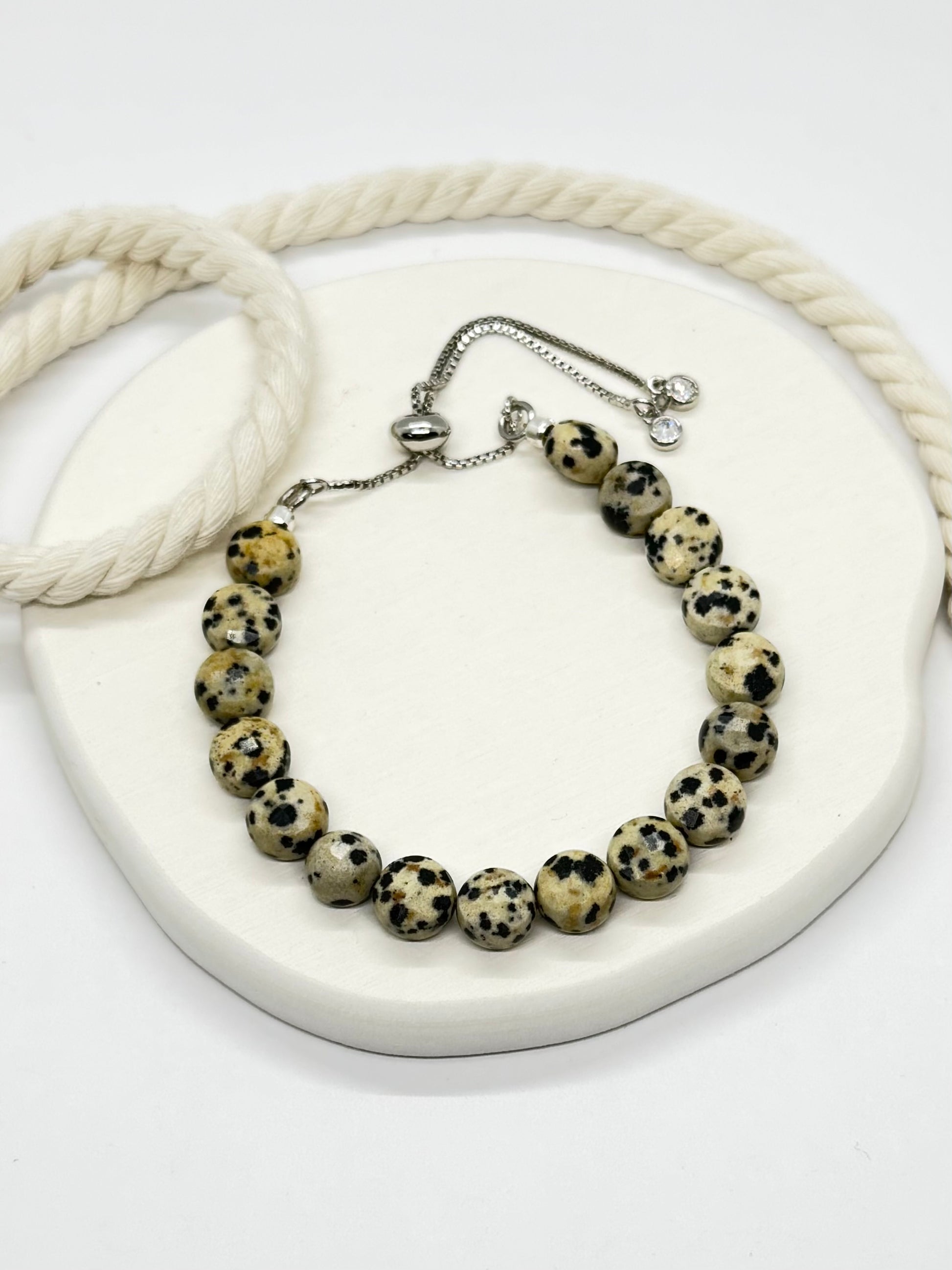 Bracelet with dalmatian jasper beads on a white surface
