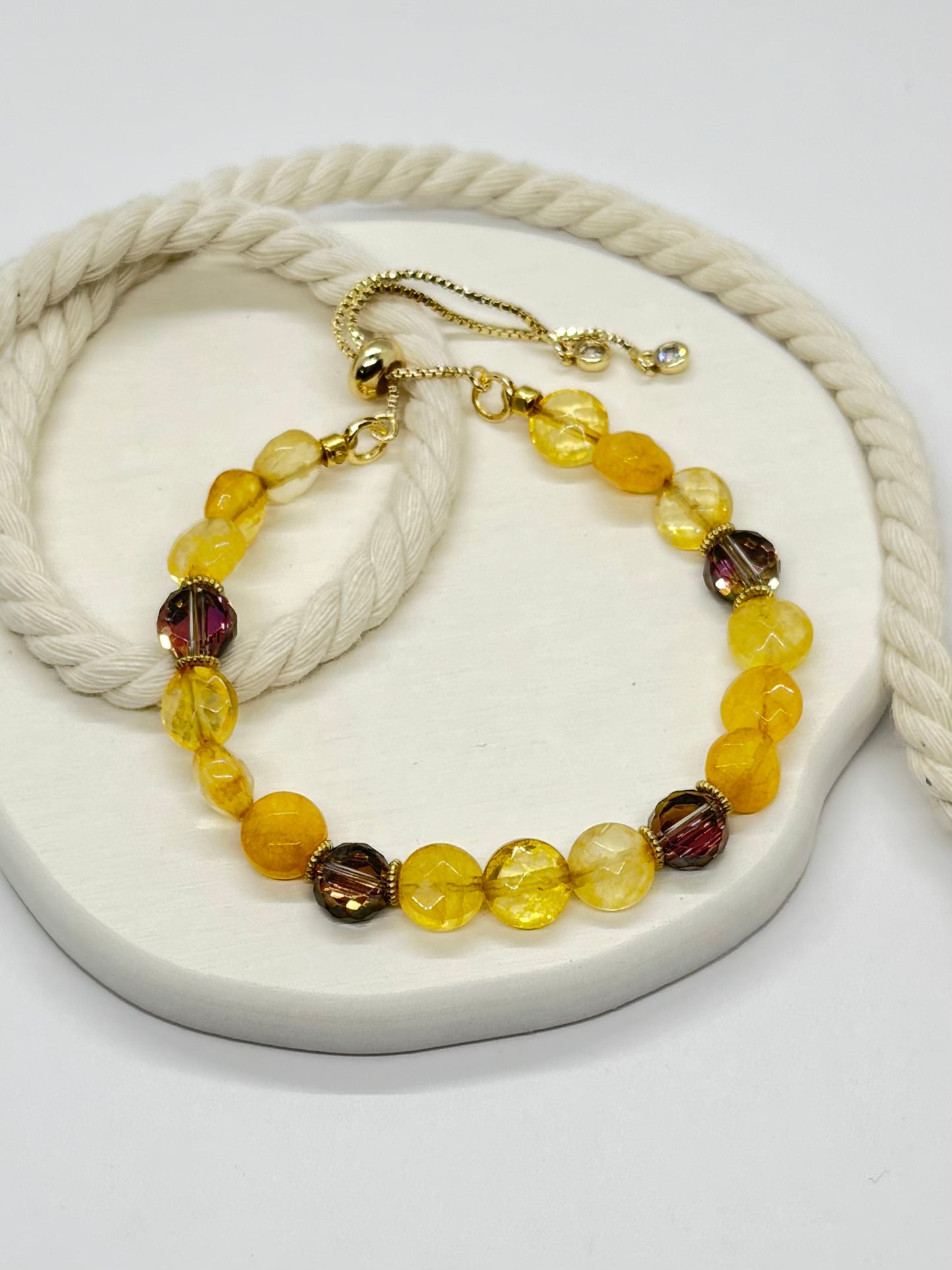 Beaded bracelet with gold clasp on a white surface