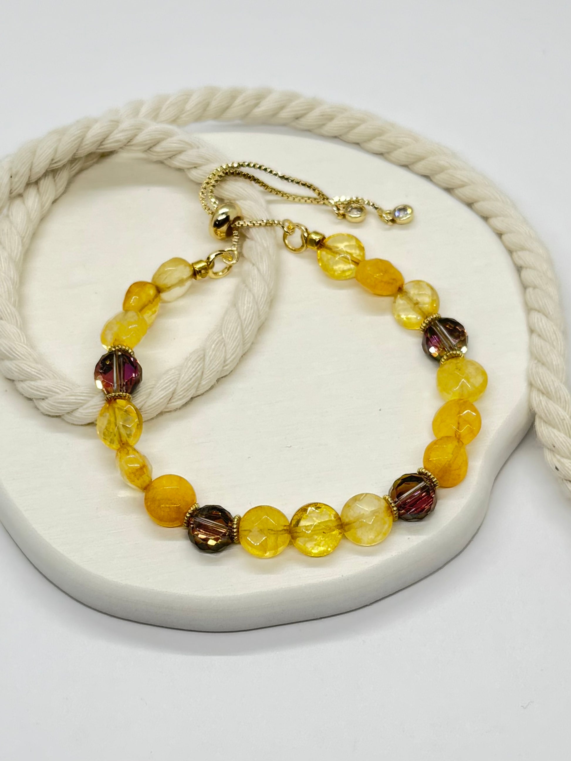 Beaded bracelet with gold clasp on a white surface