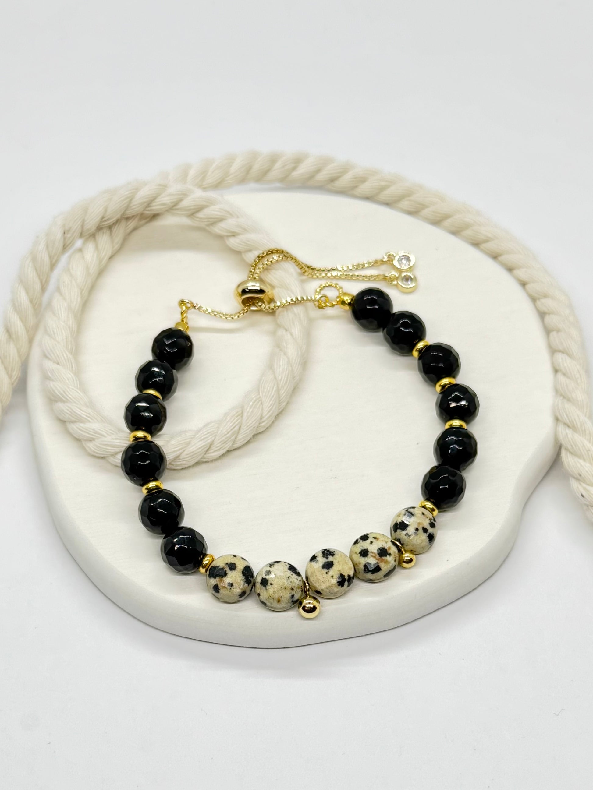 Beaded bracelet with black and gold beads on a white heart-shaped stone