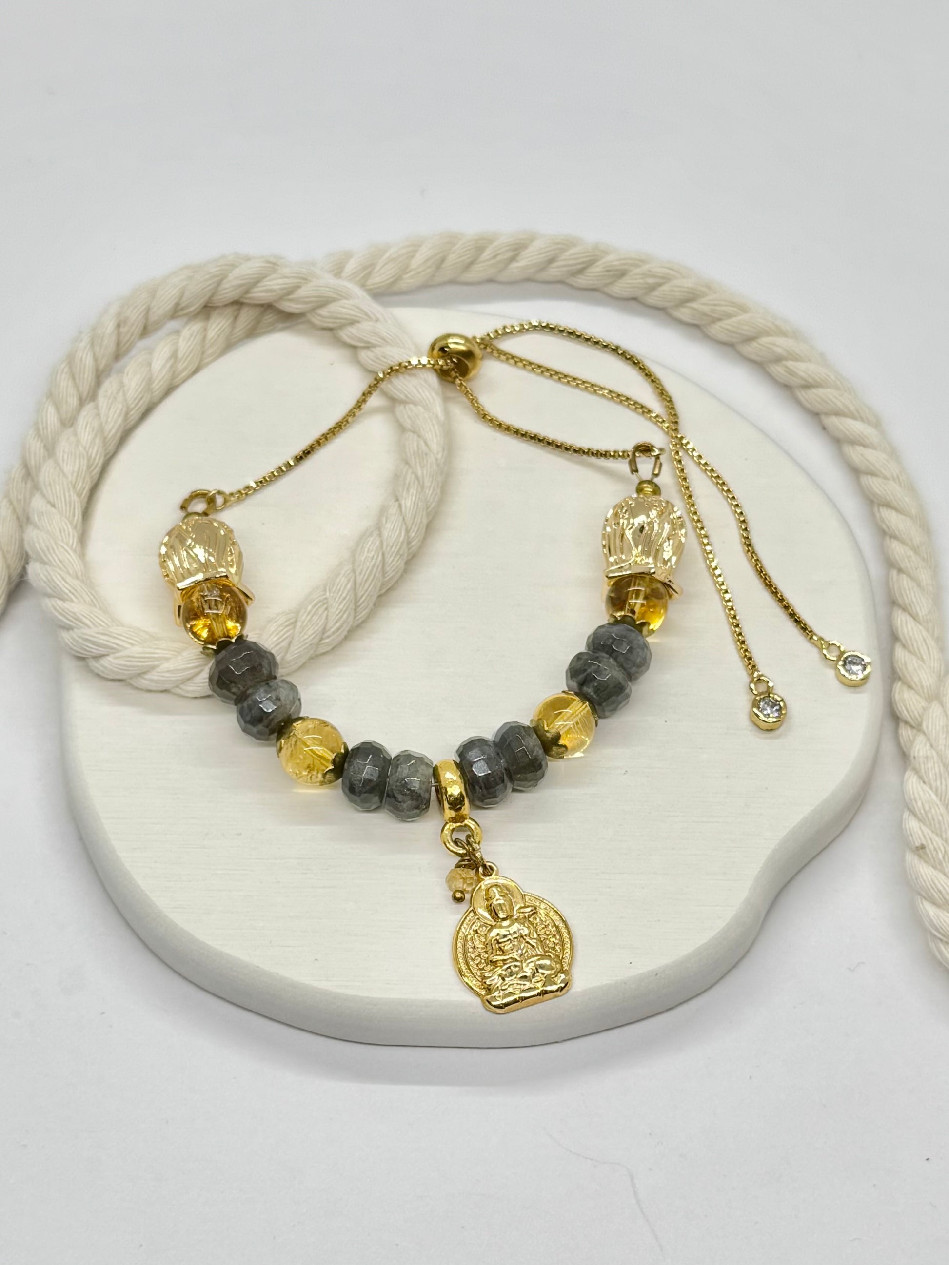 Necklace with gold and gray beads on a white stone surface