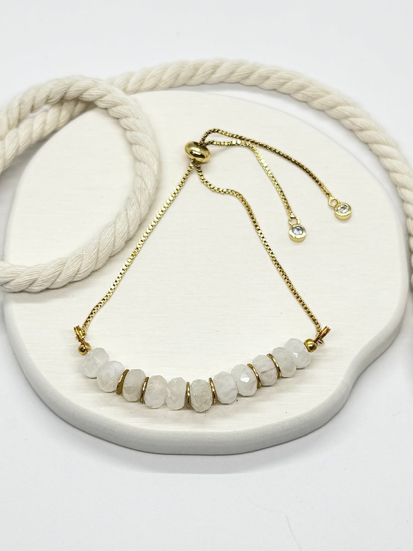 Necklace with white beads and gold chain on a white surface