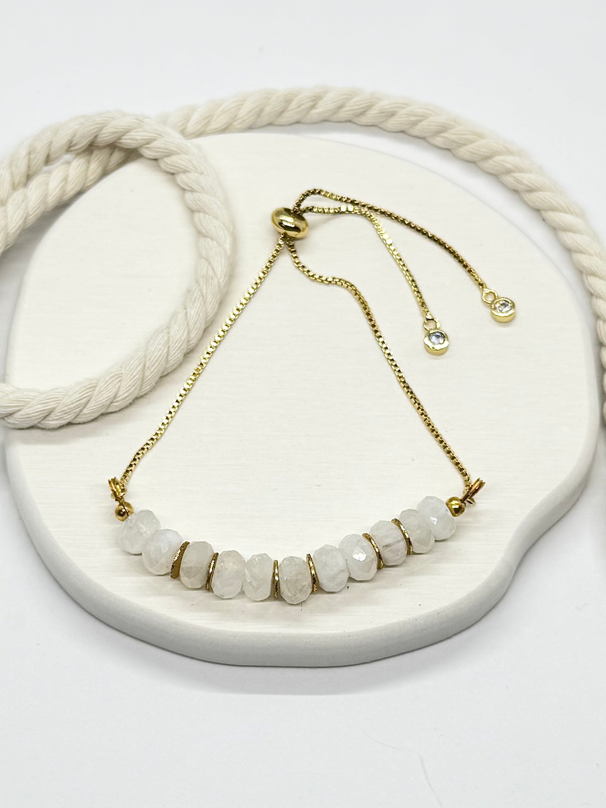 Necklace with white beads and gold chain on a white surface