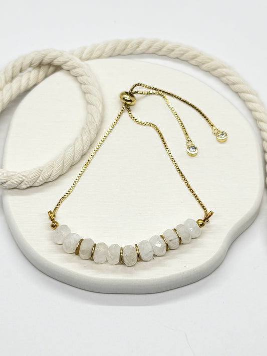 Necklace with white beads and gold chain on a white surface