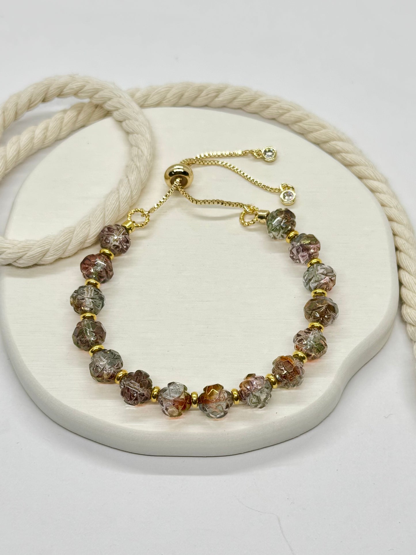 Bracelet with multicolored beads and gold accents on a white surface