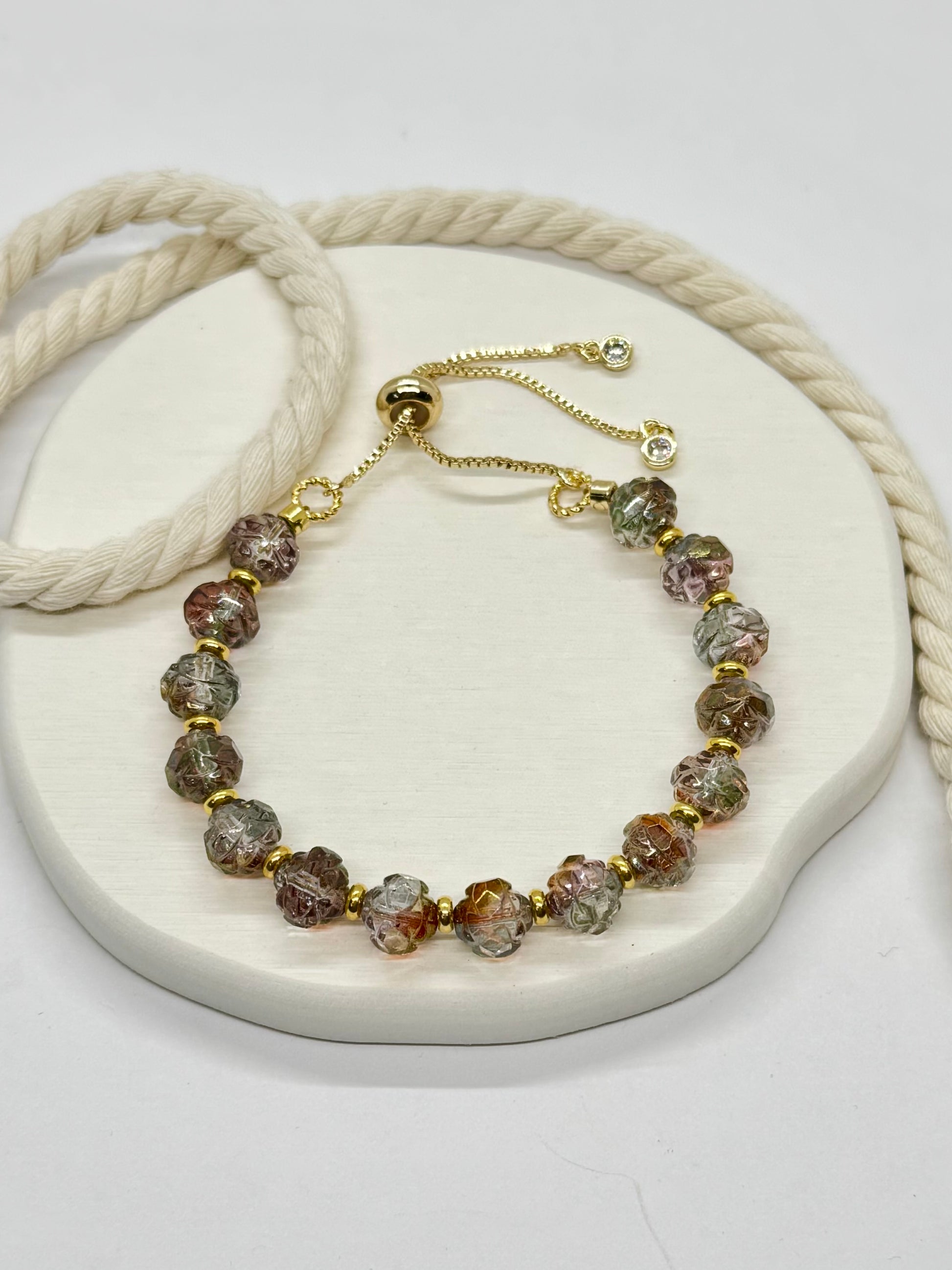 Bracelet with multicolored beads and gold accents on a white surface