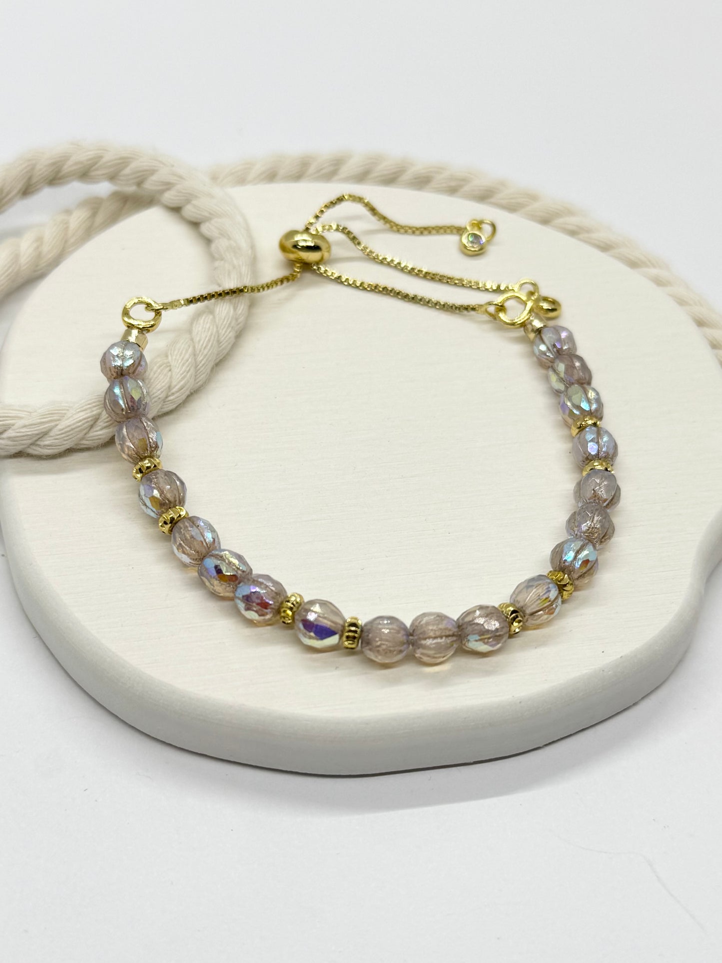 Pearl bracelet with gold accents on a white stone surface