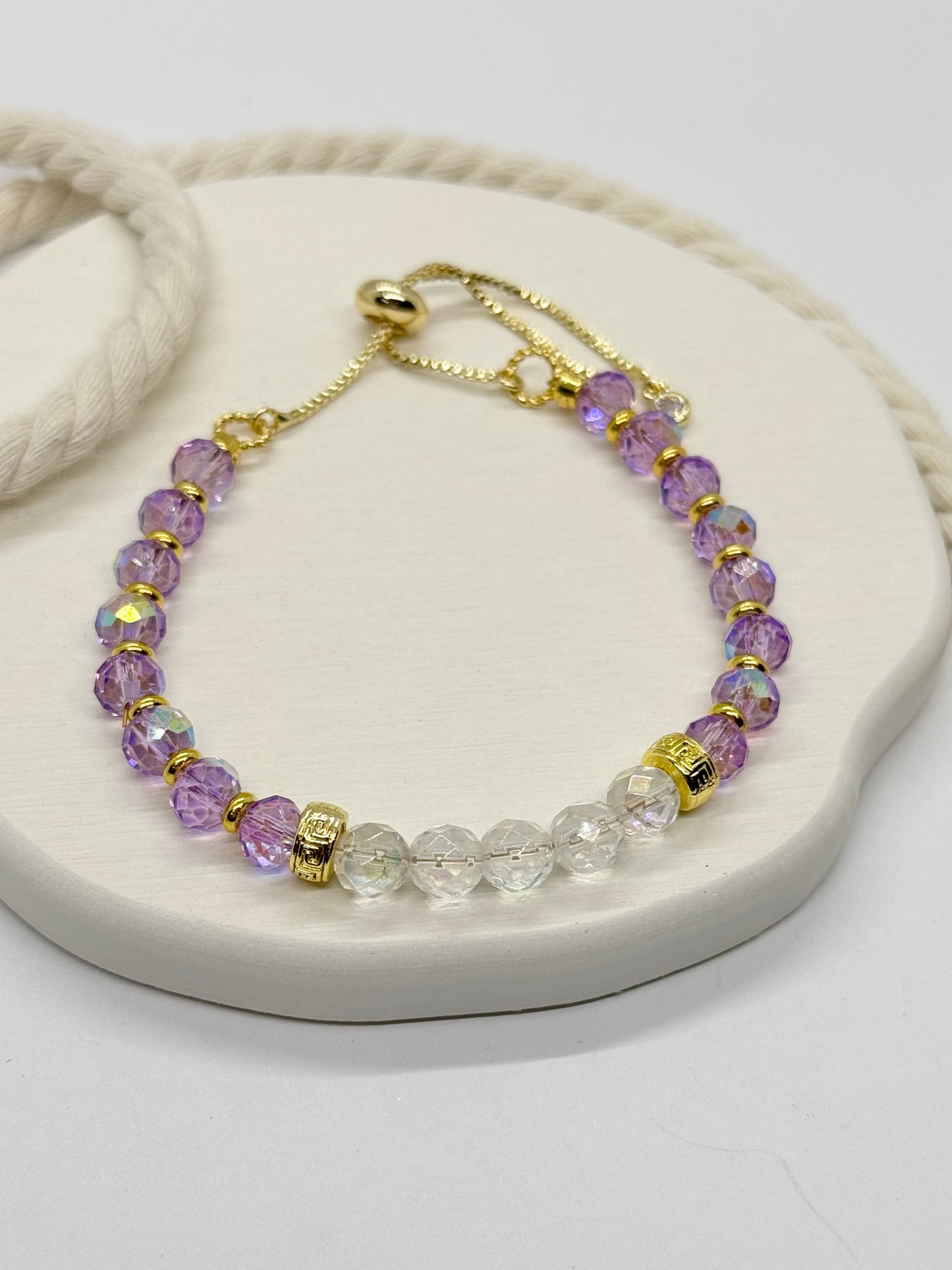 Bracelet with purple and clear beads on a white surface