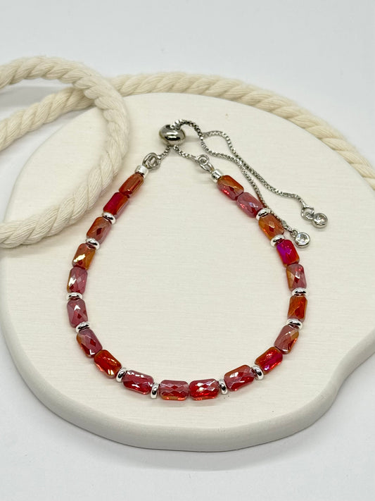 Bracelet with red beads on a white surface