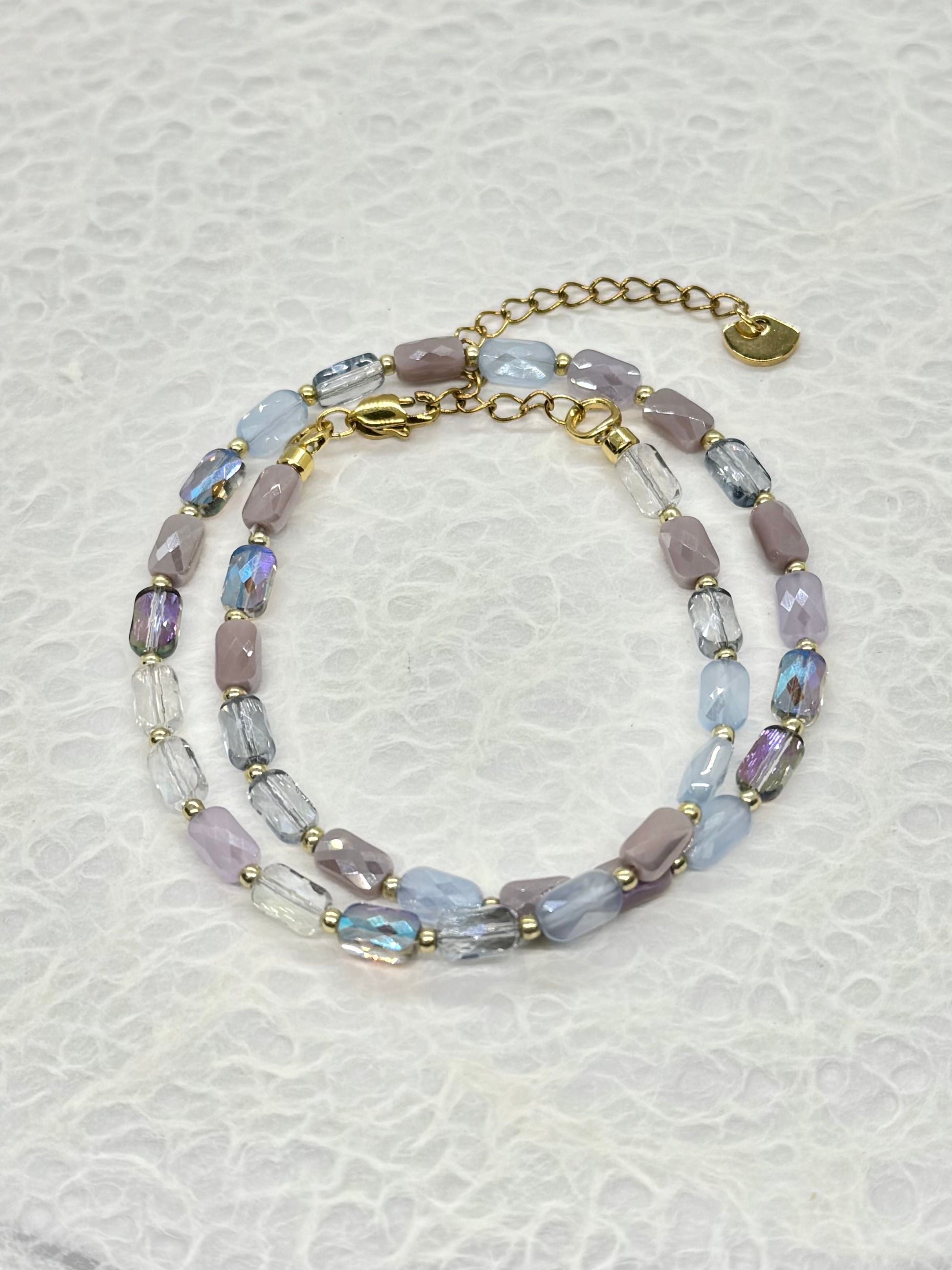 Beaded bracelet with gold accents on a textured white background