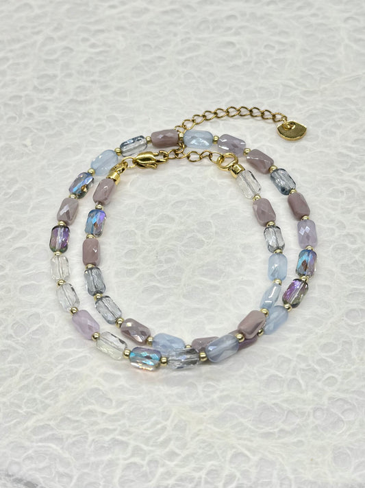 Beaded bracelet with gold accents on a textured white background