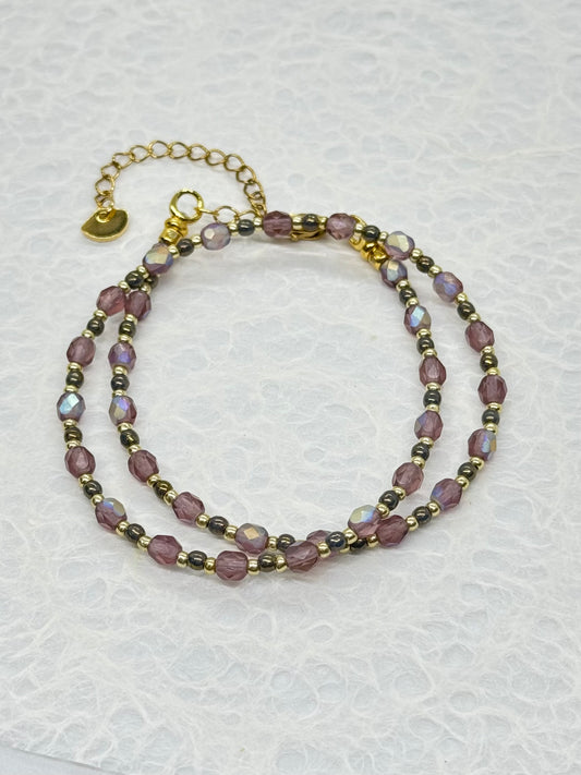 Two beaded bracelets on a textured white surface