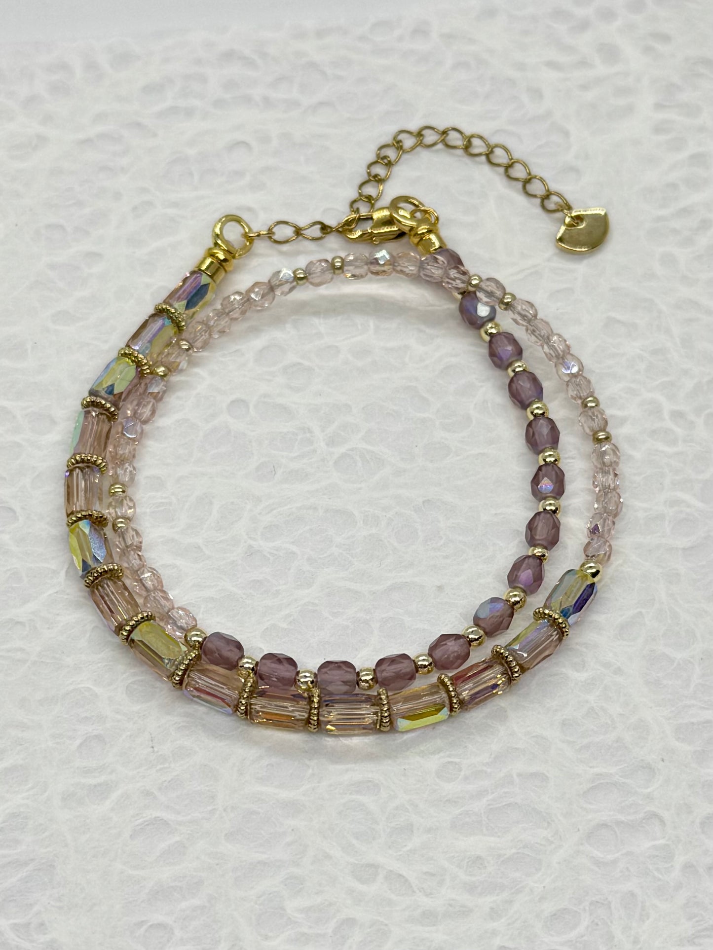 Multistrand beaded bracelet with gold accents on a textured white background
