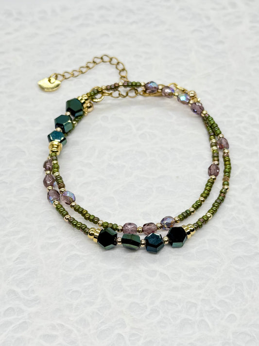 Multistrand beaded bracelet with green and purple beads on a white background