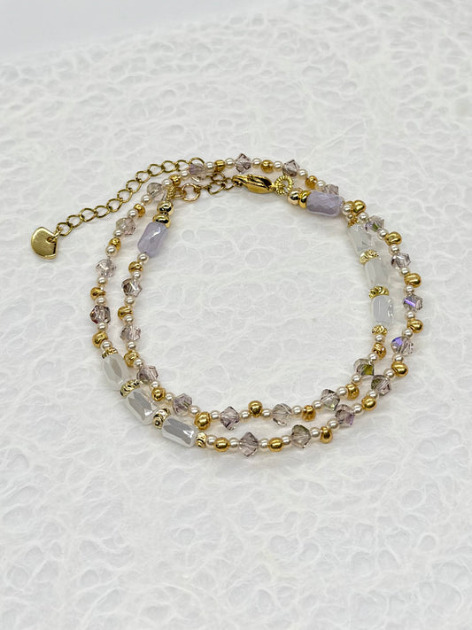 Multistrand beaded bracelet with gold accents on a textured white background