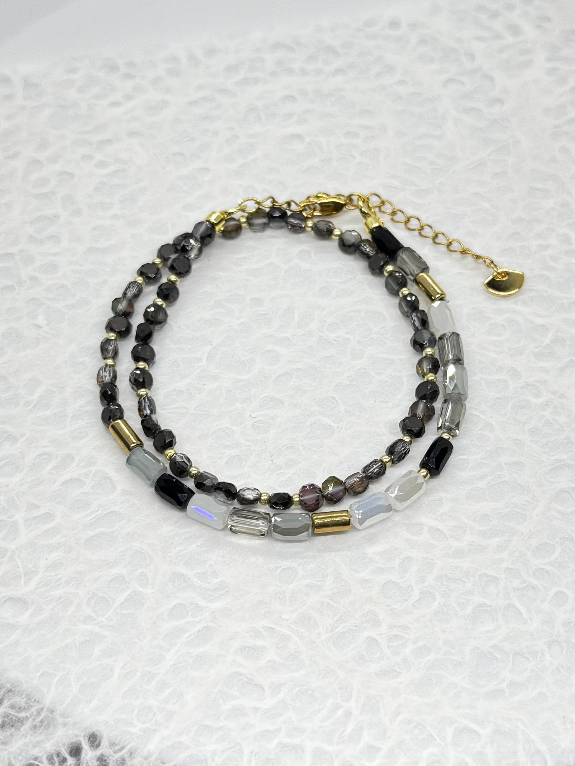 Beaded bracelet with gold accents on a textured white background