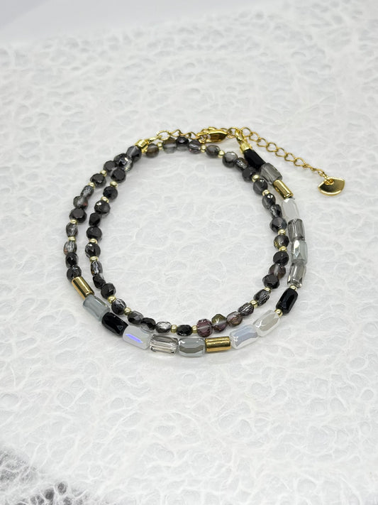 Beaded bracelet with gold accents on a textured white background