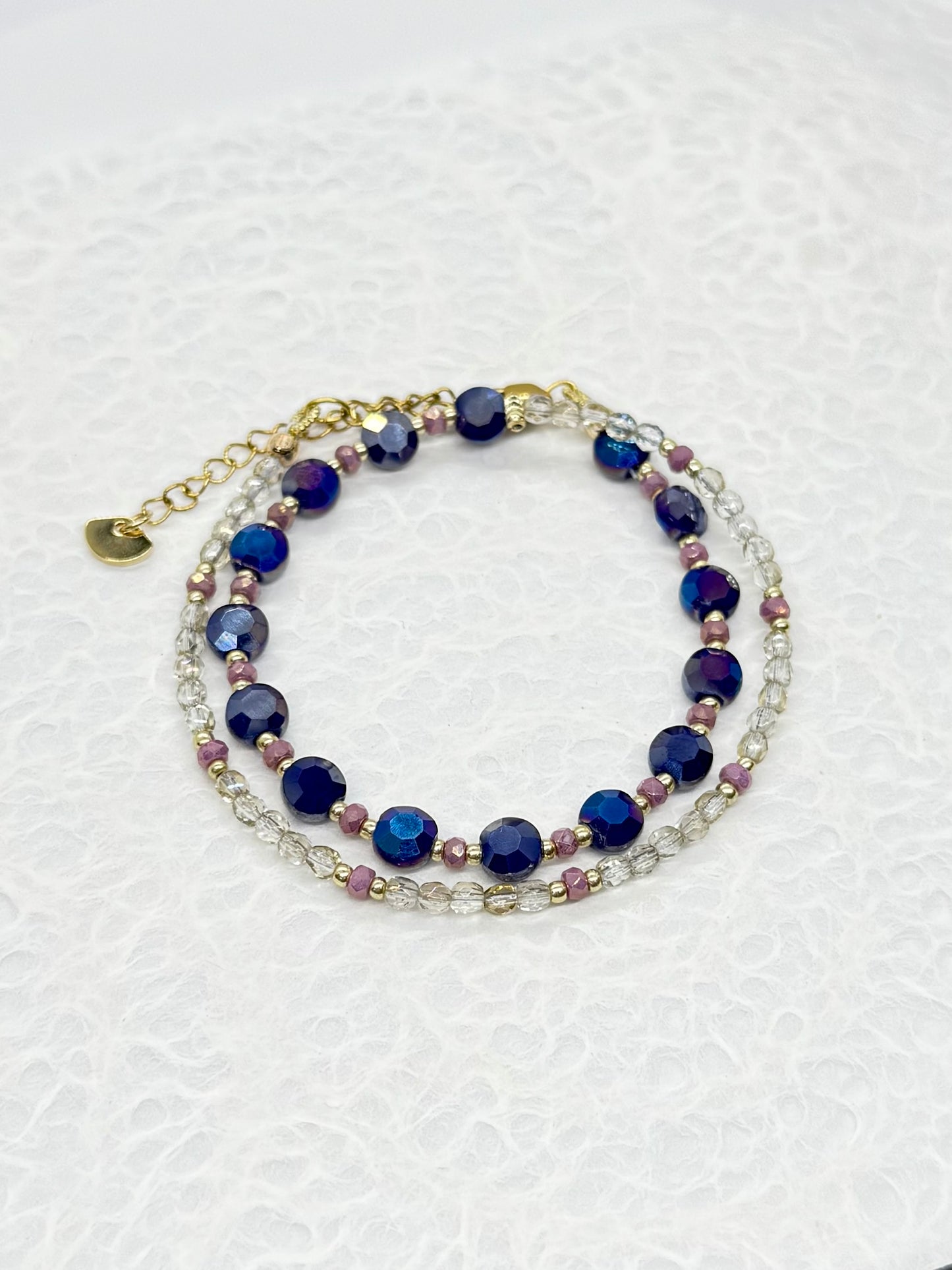 Multistrand bracelet with blue and purple beads on a white background