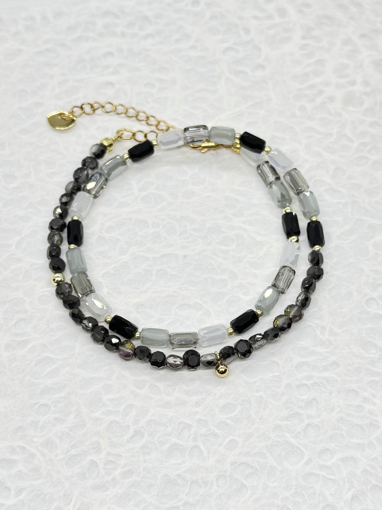 Beaded bracelet with black and clear beads on a light gray background
