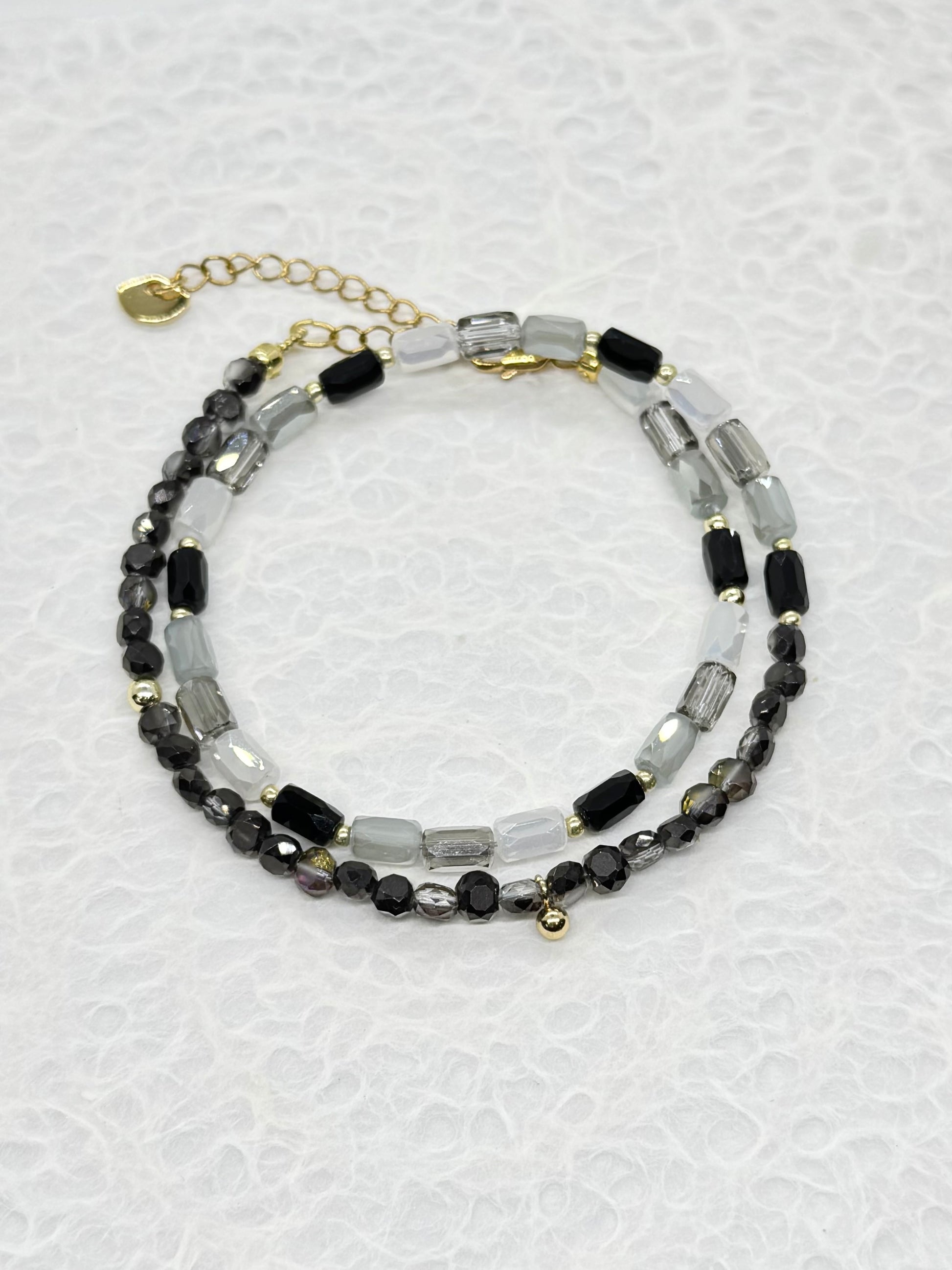 Beaded bracelet with black and clear beads on a light gray background