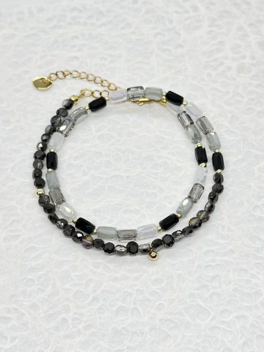 Beaded bracelet with black and clear beads on a light gray background