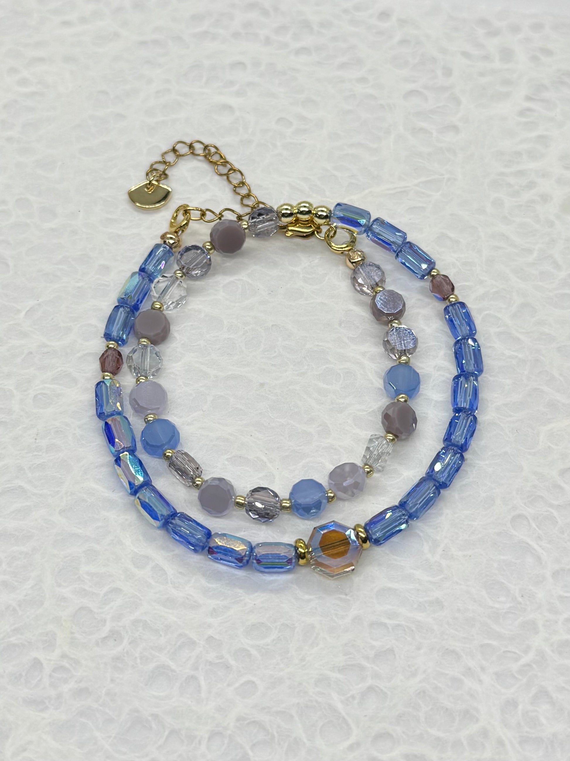 Stack of beaded bracelets on a textured white background