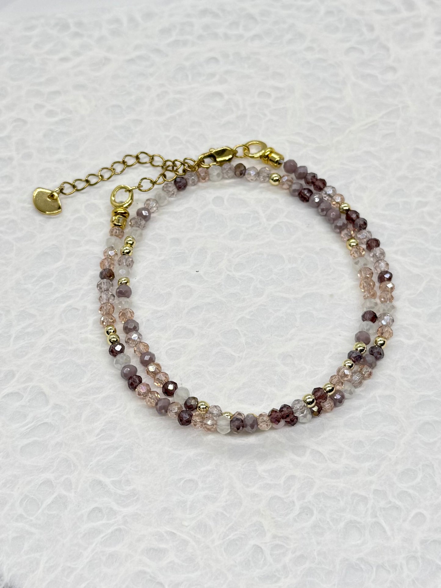 Multicolored beaded bracelet on a white textured background