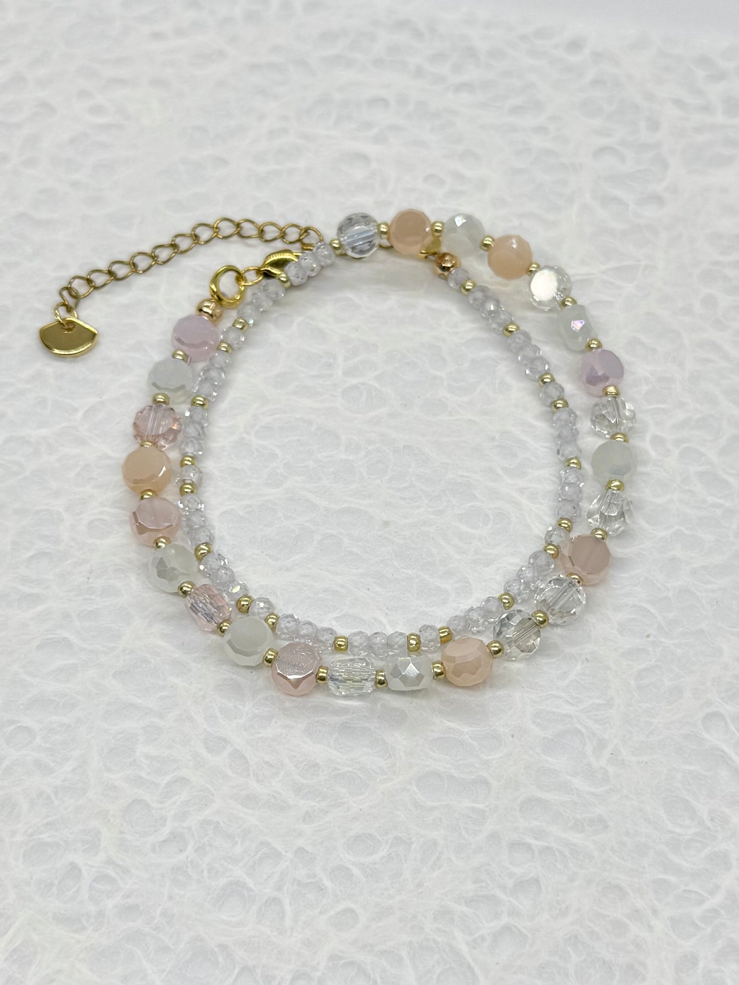 Beaded bracelet with pink and clear stones on a white background