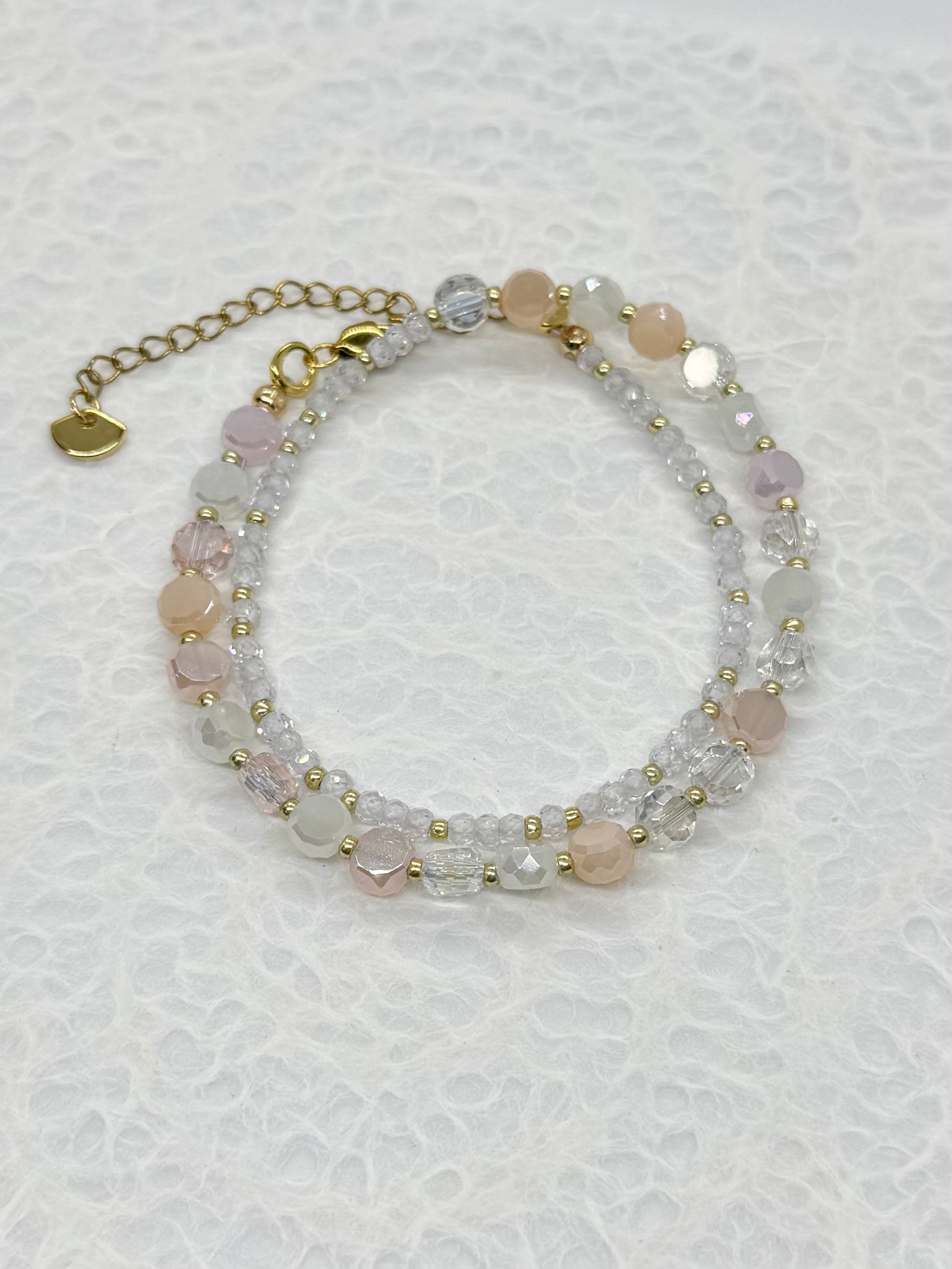 Beaded bracelet with pink and clear stones on a white background