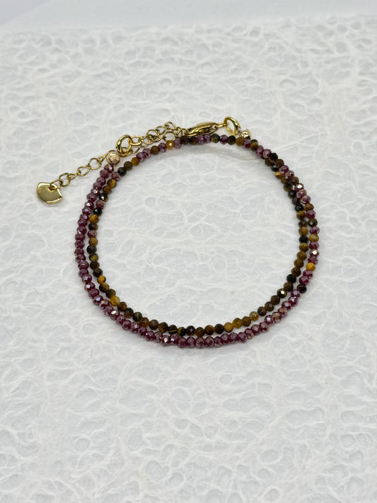 Beaded bracelet with gold clasp on a textured white background