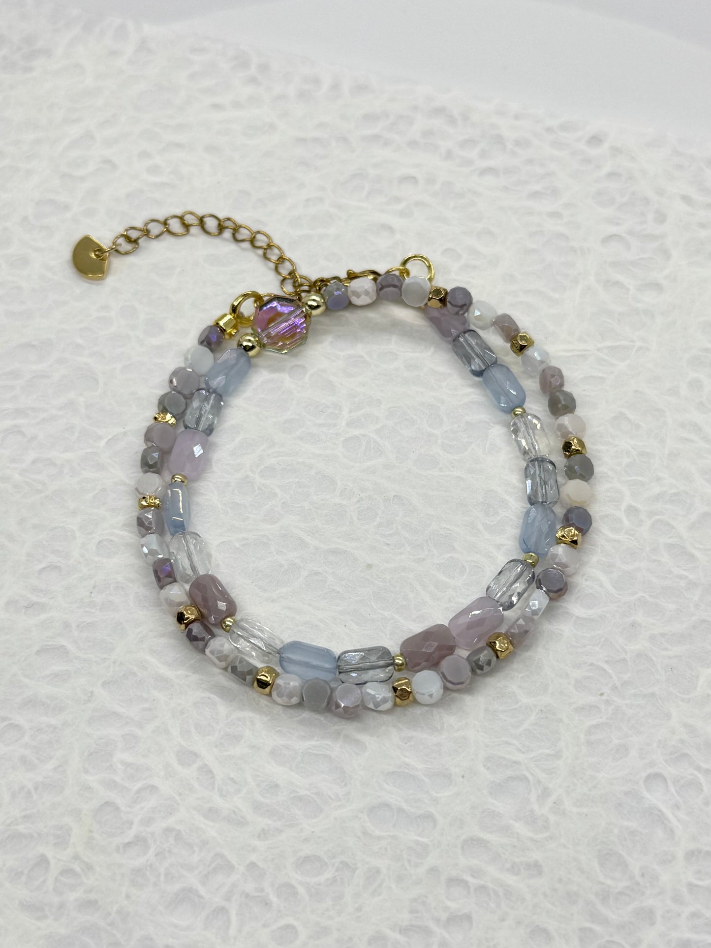 Beaded bracelet with gold accents on a textured white background