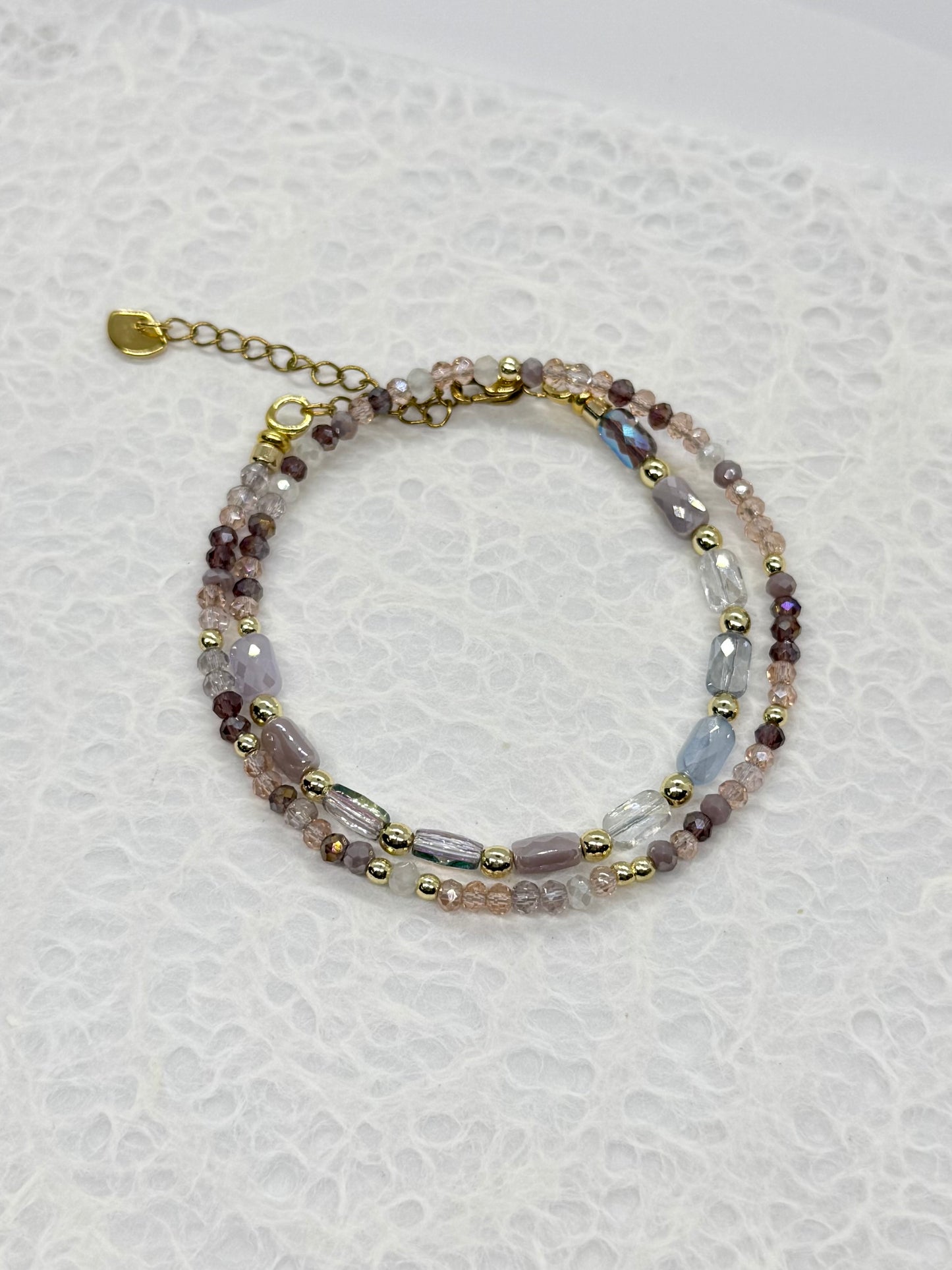 Multicolored beaded bracelet on a white textured background