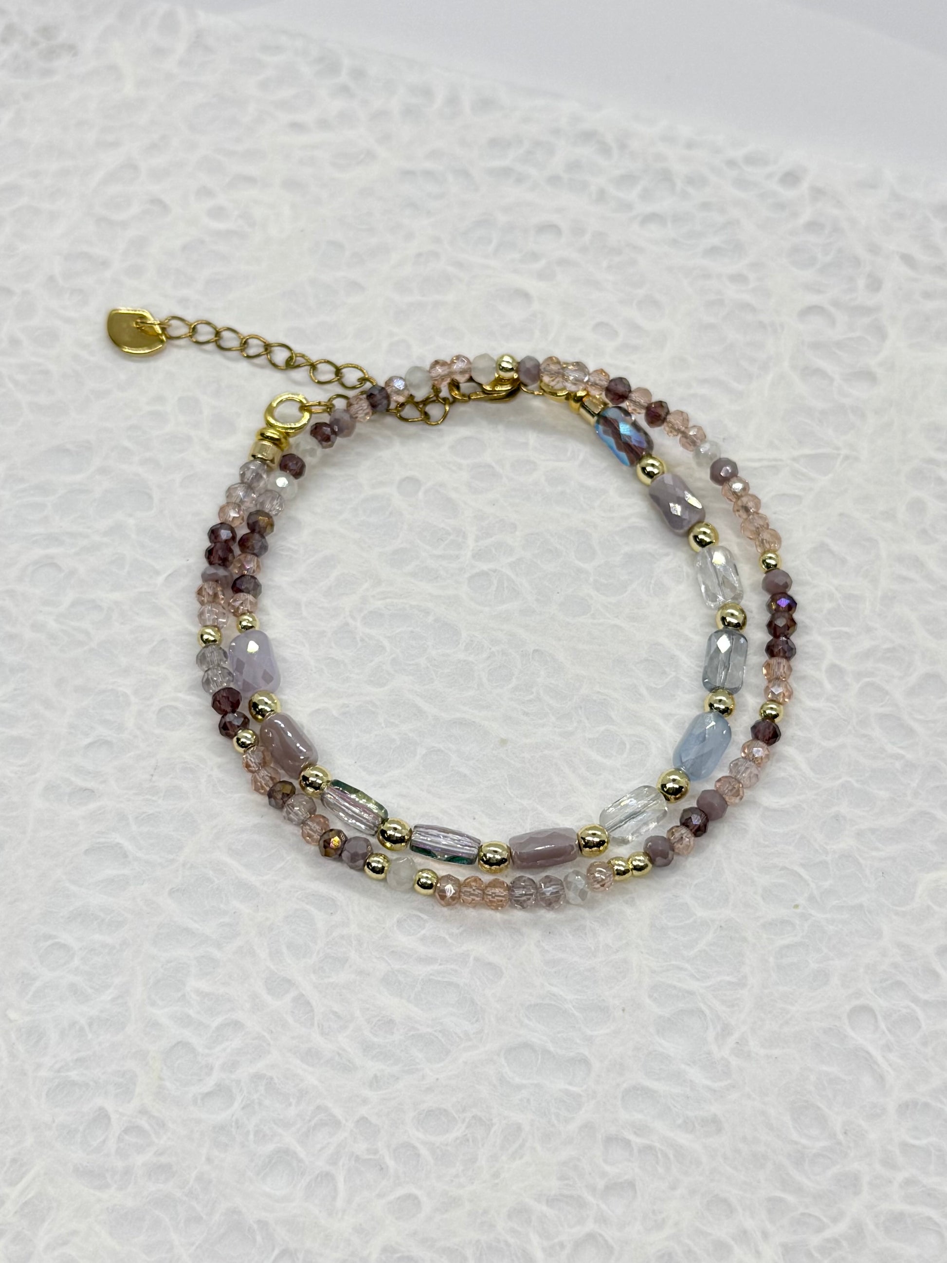 Multicolored beaded bracelet on a white textured background