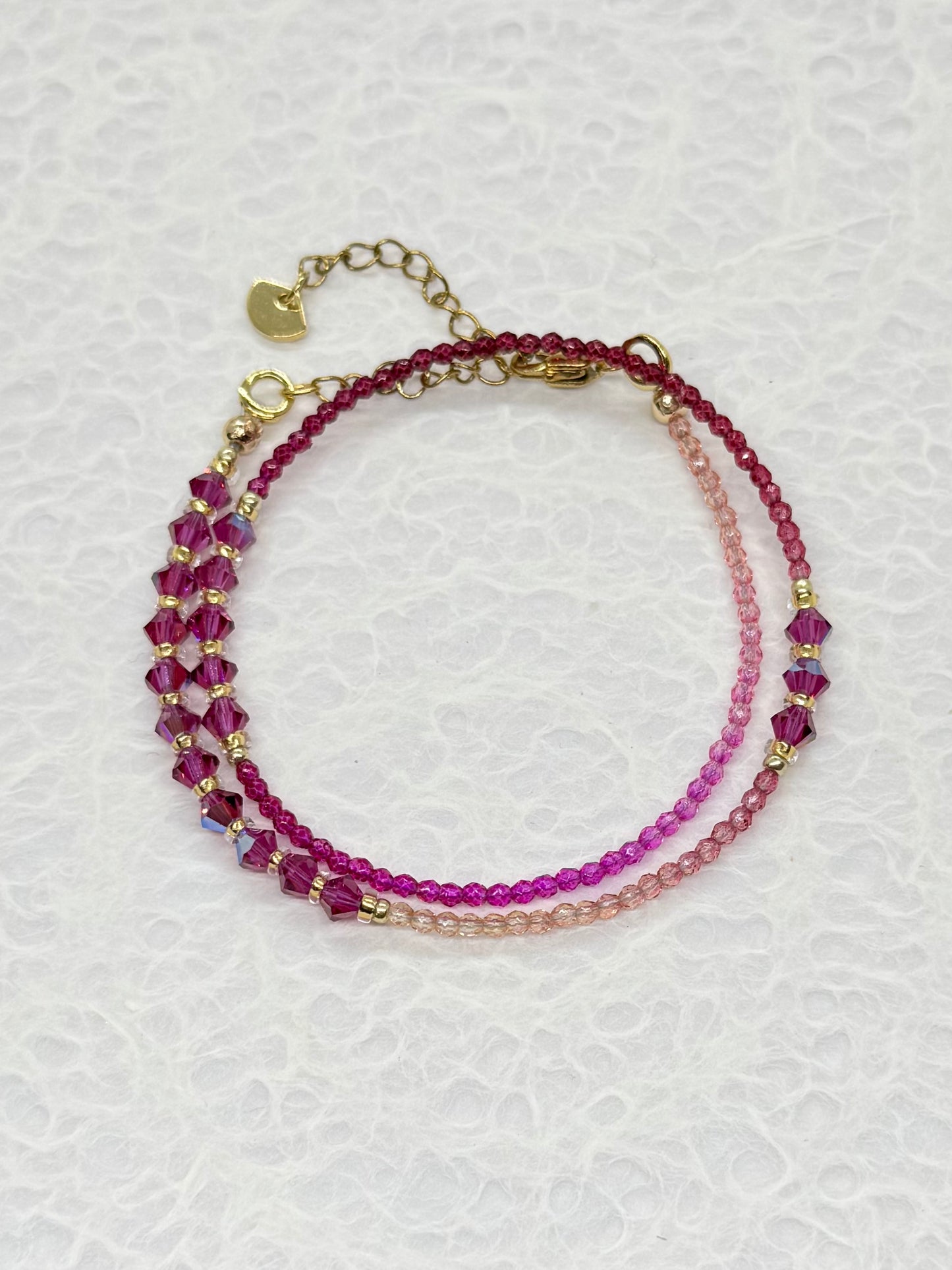 Stack of beaded bracelets on a textured white surface