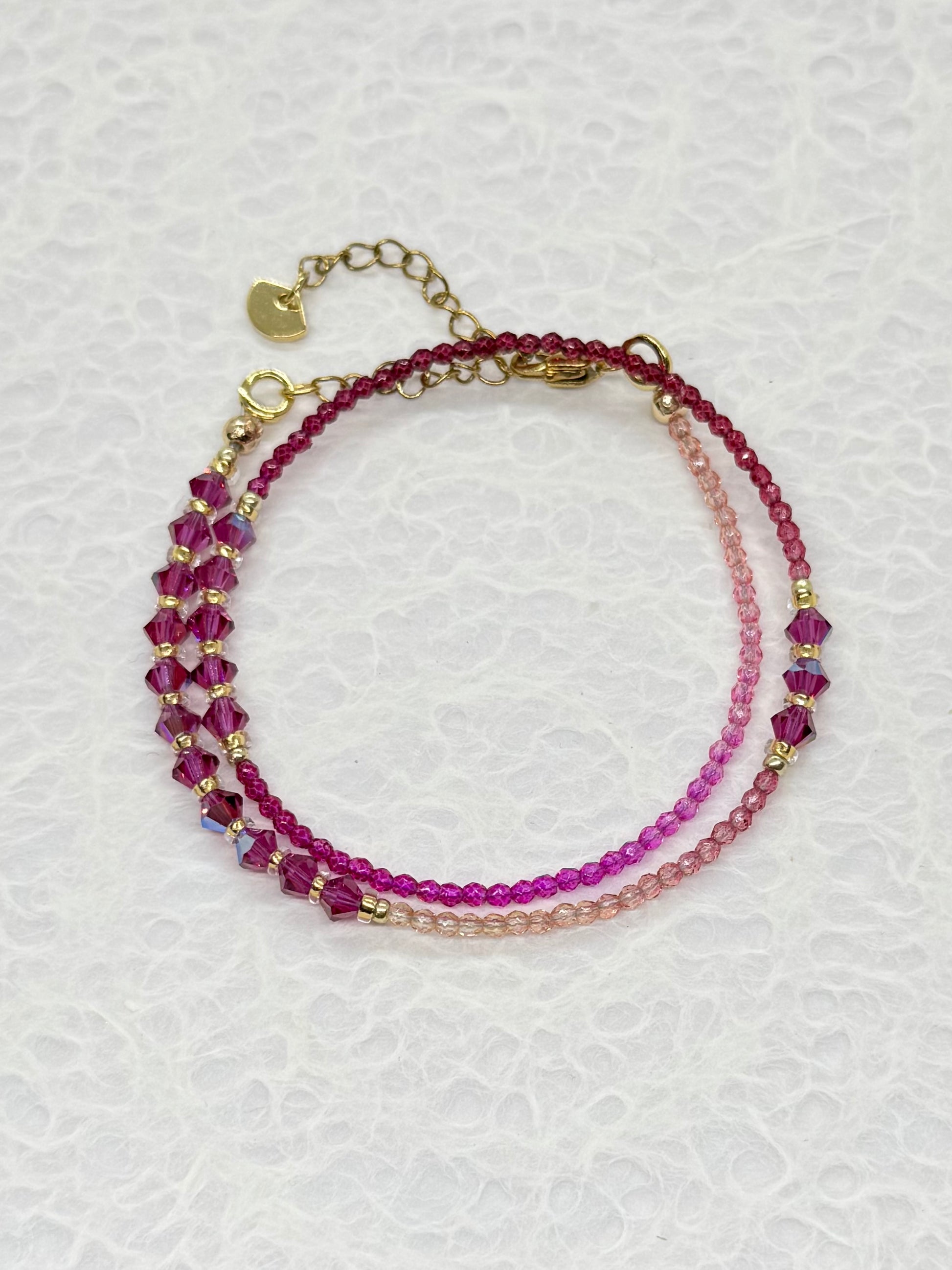 Stack of beaded bracelets on a textured white surface